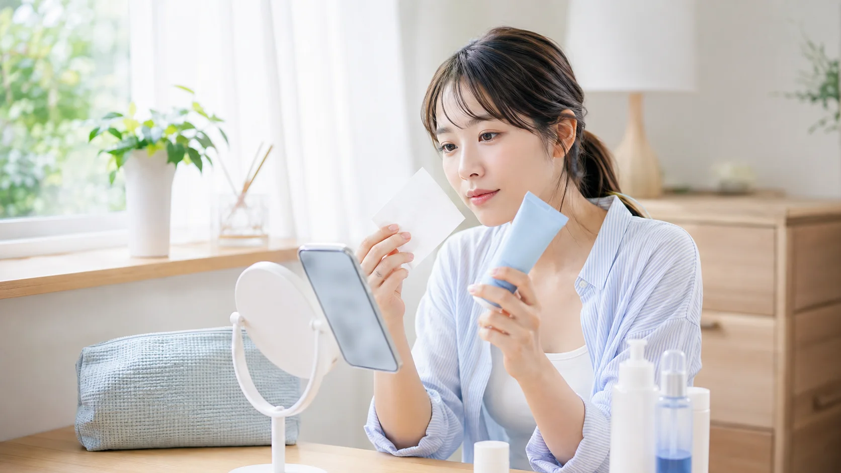 日焼け止めとティッシュオフの方法を調べる女性