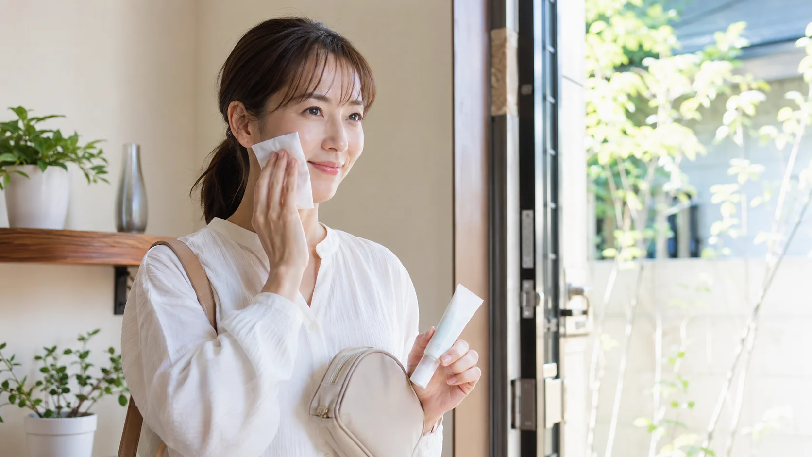 日焼け止めを塗って外出前に優しくティッシュオフする女性